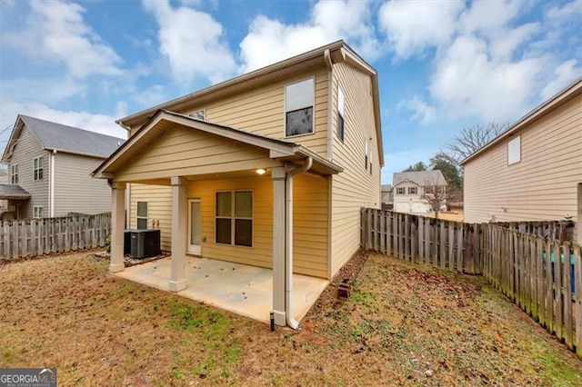 back of property with central AC and a patio area