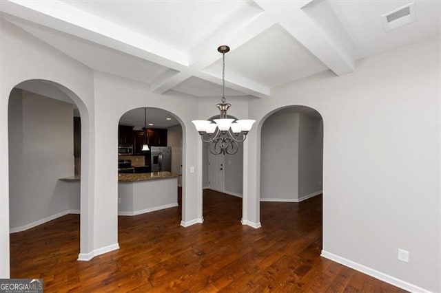 unfurnished dining area featuring dark wood-type flooring, coffered ceiling, beam ceiling, and an inviting chandelier