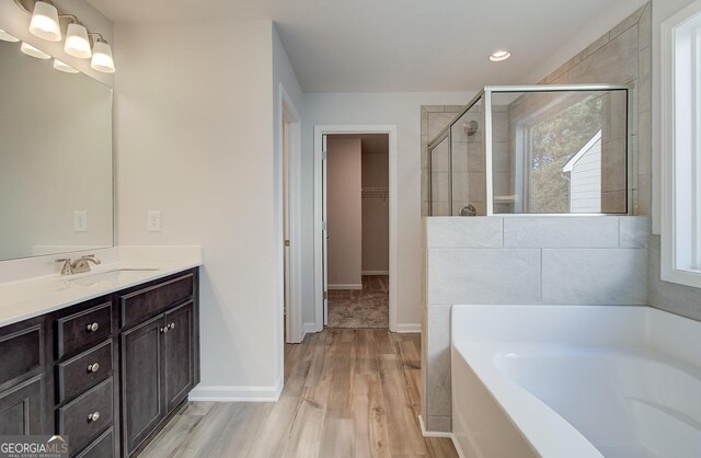 bathroom featuring vanity, hardwood / wood-style flooring, plenty of natural light, and shower with separate bathtub