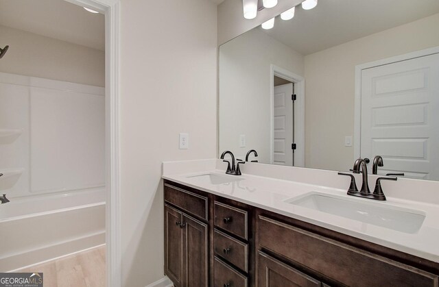 bathroom featuring vanity, hardwood / wood-style floors, and bathtub / shower combination