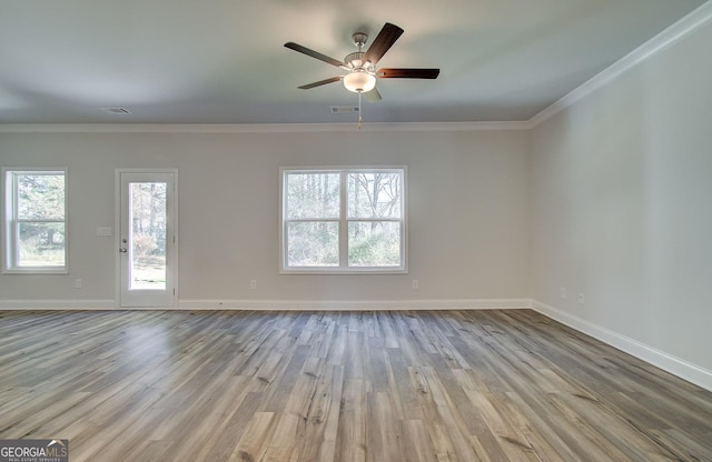 unfurnished room with plenty of natural light, ornamental molding, and light wood-type flooring