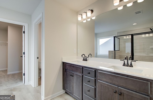 bathroom featuring vanity, toilet, and a shower with shower door