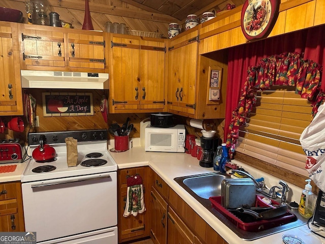 kitchen featuring sink, white appliances, and wooden walls