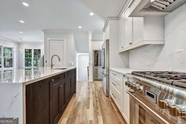 kitchen featuring sink, white cabinetry, tasteful backsplash, premium appliances, and ornamental molding