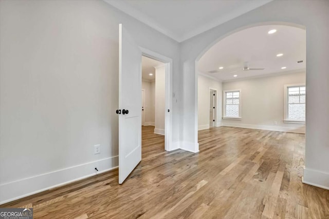 spare room featuring ornamental molding and light hardwood / wood-style flooring