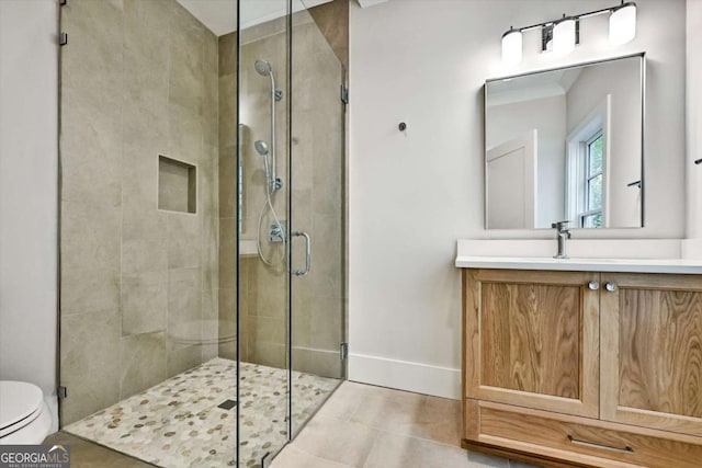 bathroom featuring vanity, tile patterned flooring, a shower with shower door, and toilet