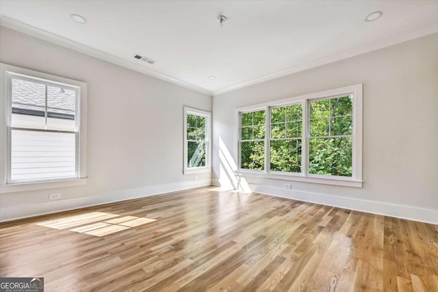 unfurnished room with crown molding and light hardwood / wood-style floors