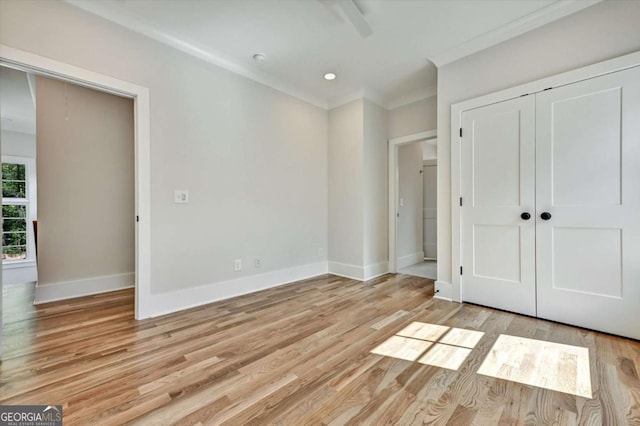 unfurnished bedroom featuring a closet, crown molding, ceiling fan, and light hardwood / wood-style flooring