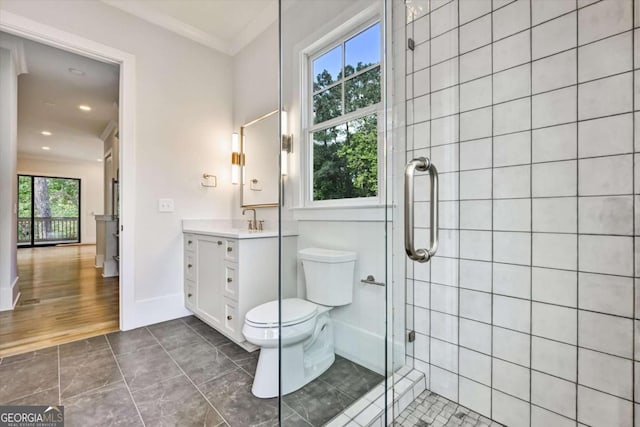 bathroom featuring vanity, crown molding, toilet, and walk in shower