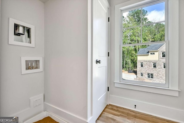 laundry area featuring hookup for a washing machine and light hardwood / wood-style floors