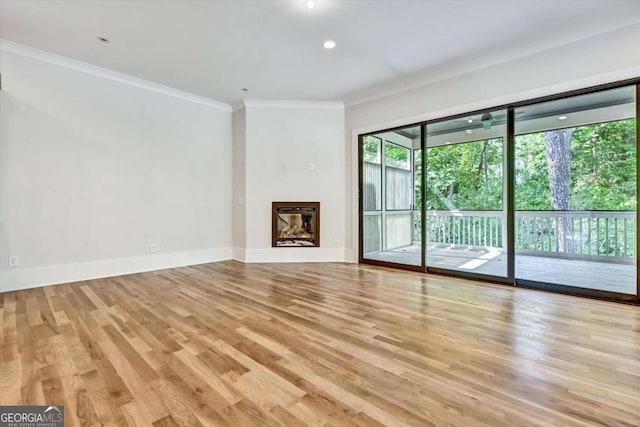 unfurnished living room with ornamental molding and light hardwood / wood-style floors