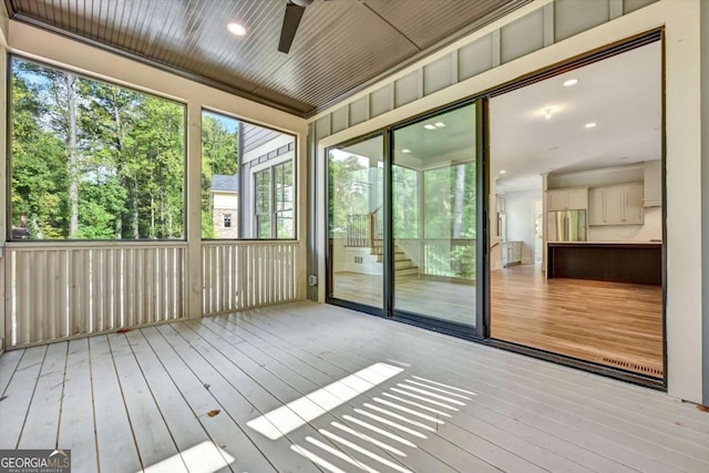 unfurnished sunroom featuring plenty of natural light and ceiling fan