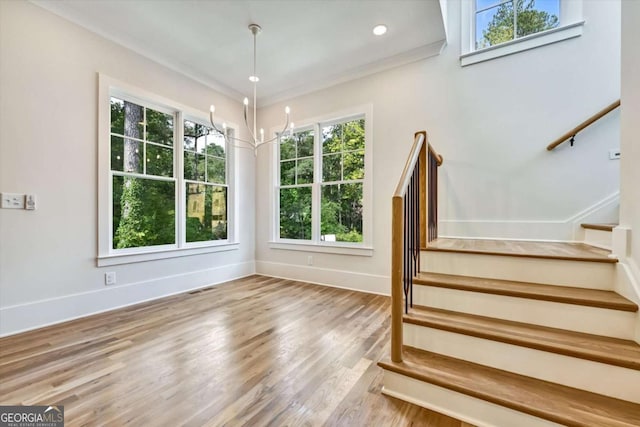 stairway with hardwood / wood-style flooring and crown molding