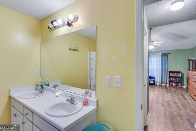 bathroom with vanity, ceiling fan, wood-type flooring, and a textured ceiling