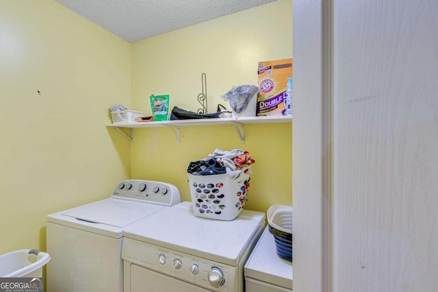 laundry room with a textured ceiling and washing machine and clothes dryer