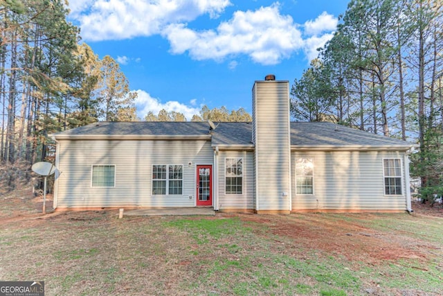 rear view of property with a lawn and a patio