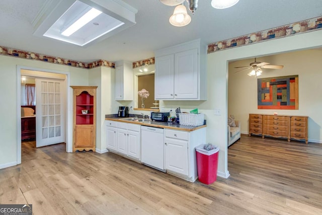 kitchen with sink, white dishwasher, light wood-type flooring, and white cabinets