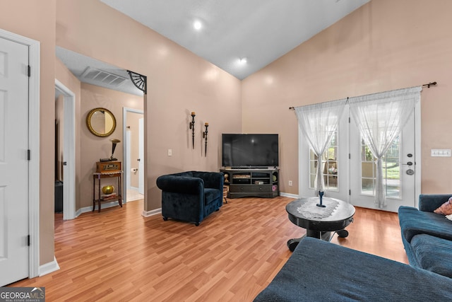 living room featuring light hardwood / wood-style flooring and high vaulted ceiling