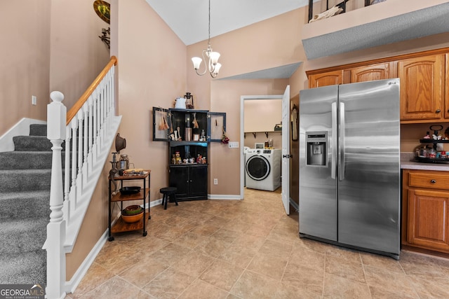 kitchen with pendant lighting, lofted ceiling, a notable chandelier, independent washer and dryer, and stainless steel refrigerator with ice dispenser