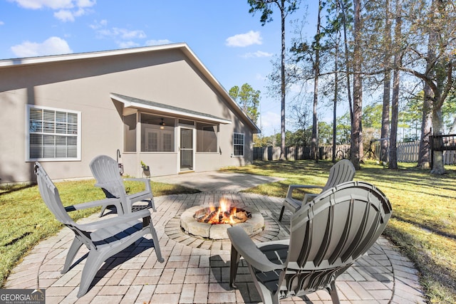 view of patio / terrace with a sunroom and an outdoor fire pit