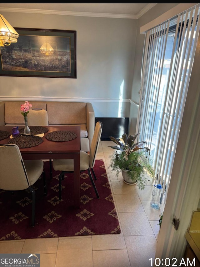 dining space featuring crown molding and light tile patterned floors