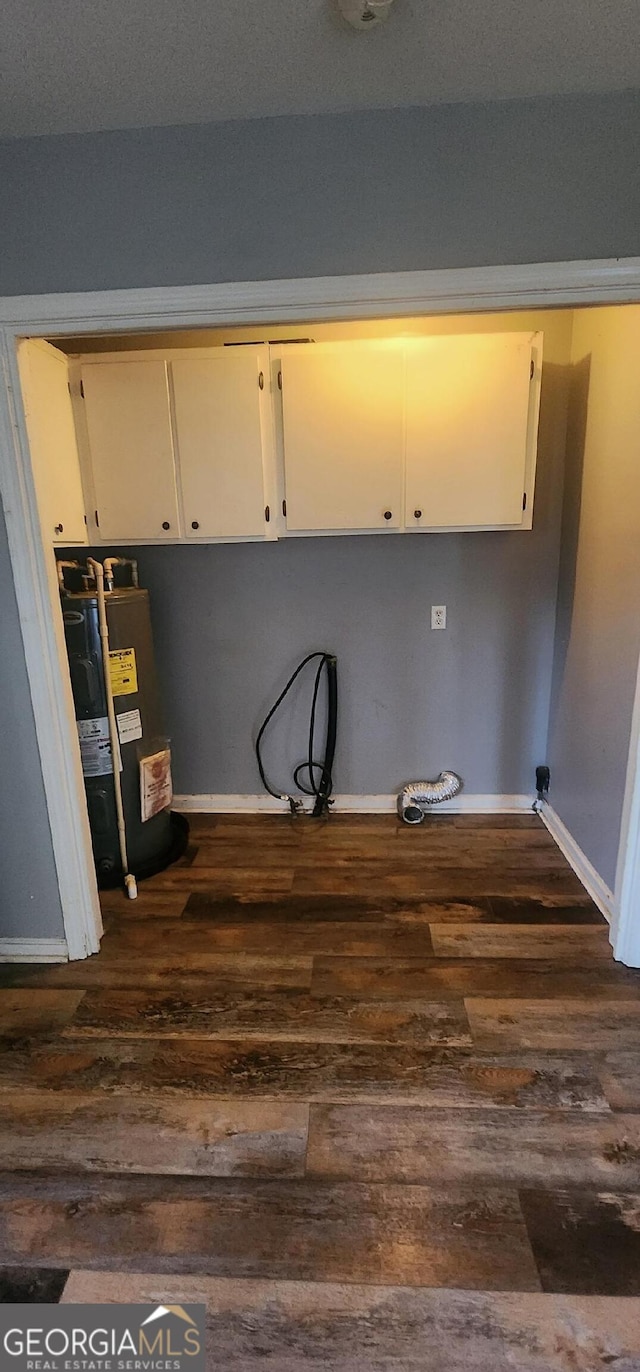 laundry area with cabinets, dark hardwood / wood-style flooring, and water heater