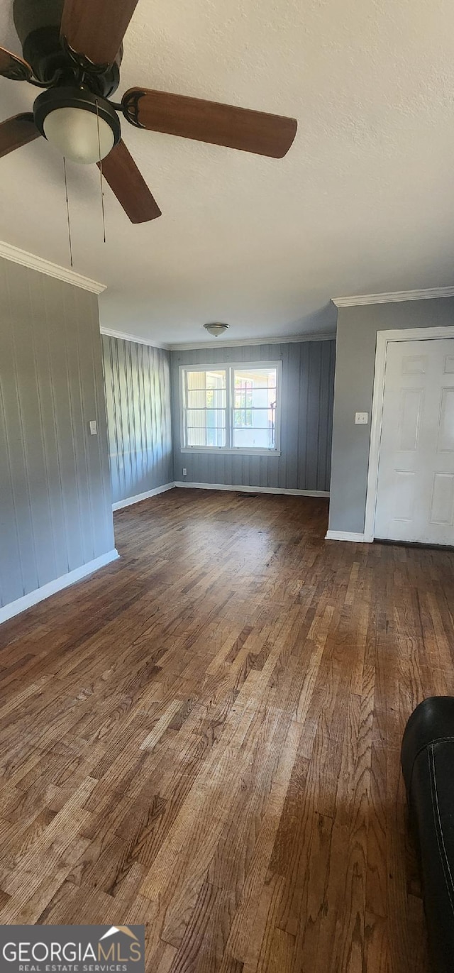 unfurnished living room featuring hardwood / wood-style flooring, ceiling fan, and ornamental molding