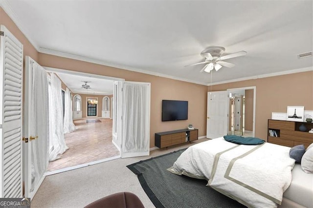 bedroom featuring light colored carpet, ornamental molding, and ceiling fan