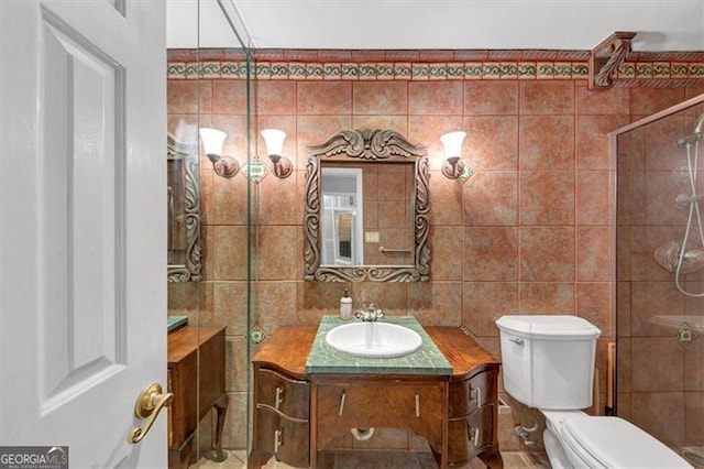 bathroom featuring tile walls, vanity, and toilet