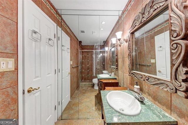 bathroom featuring tile walls, an enclosed shower, vanity, and toilet