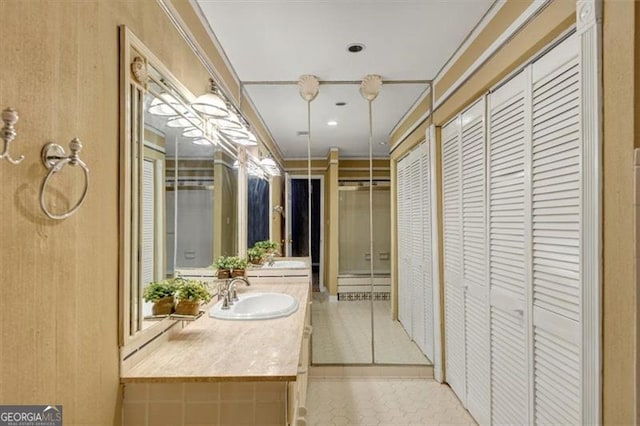 bathroom with crown molding, vanity, and tile patterned floors