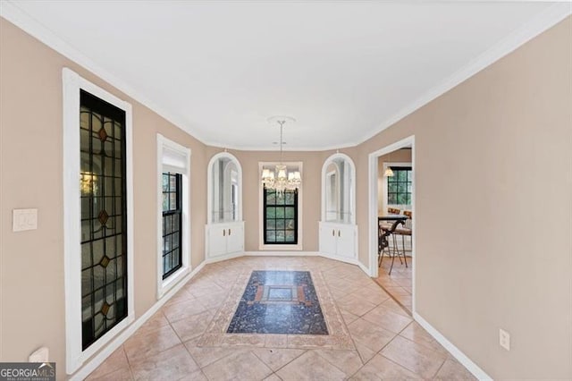 entryway with an inviting chandelier, ornamental molding, and light tile patterned floors