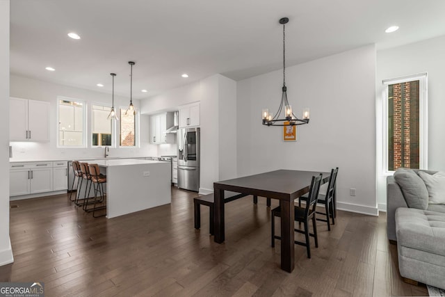 dining room with dark wood-type flooring and an inviting chandelier