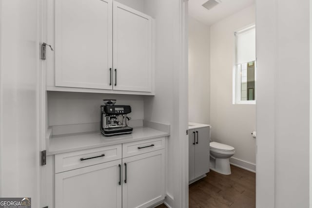 bathroom with vanity, toilet, and hardwood / wood-style floors