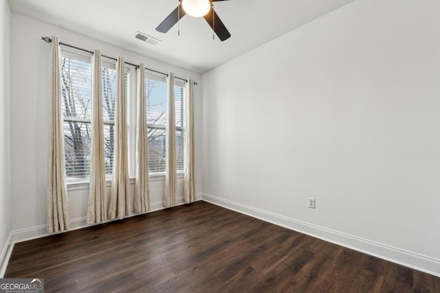 spare room with dark wood-type flooring and ceiling fan