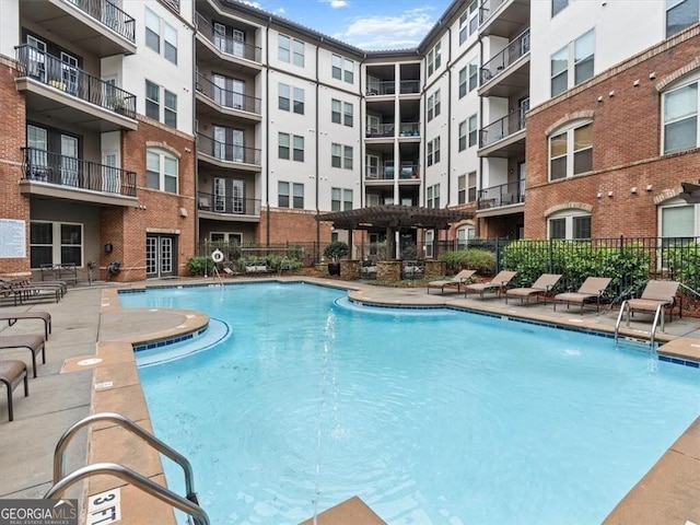 view of pool with a patio, a pergola, and pool water feature