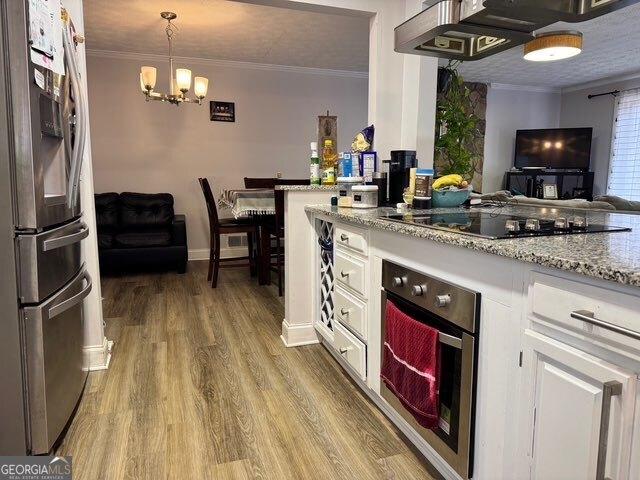 kitchen with white cabinetry, wood-type flooring, custom exhaust hood, stainless steel appliances, and crown molding