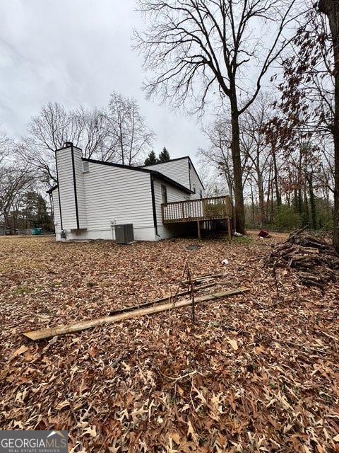 view of side of property featuring cooling unit and a deck