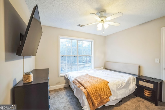 carpeted bedroom featuring a textured ceiling and ceiling fan