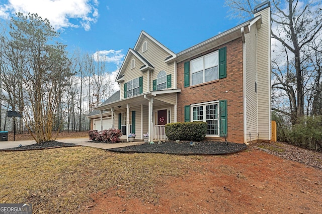 view of front of home with a garage, a front yard, and a porch