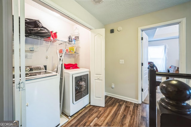 clothes washing area with dark wood-type flooring, independent washer and dryer, and a textured ceiling