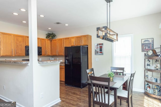 kitchen with decorative light fixtures, dark hardwood / wood-style flooring, kitchen peninsula, and black appliances