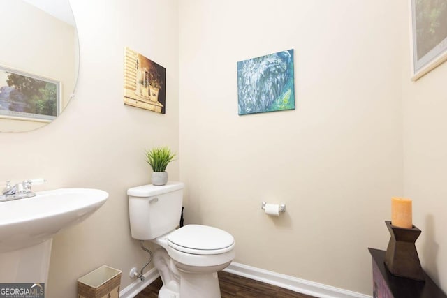 bathroom featuring wood-type flooring, toilet, and sink