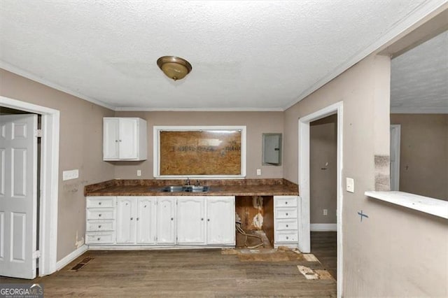 kitchen with sink, a textured ceiling, and white cabinets