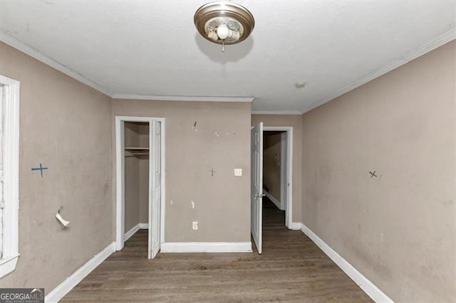 unfurnished bedroom featuring a closet, crown molding, and dark hardwood / wood-style floors