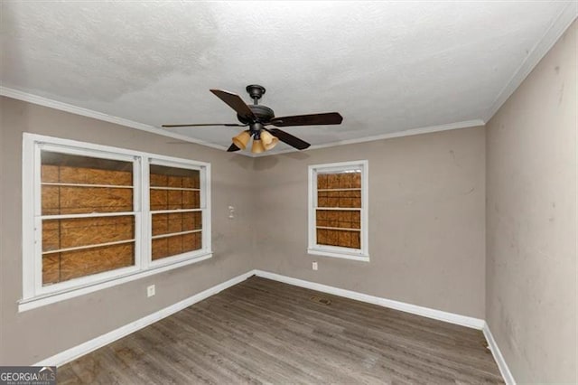 empty room with ceiling fan, ornamental molding, dark hardwood / wood-style flooring, and a textured ceiling