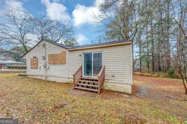 rear view of house featuring a lawn