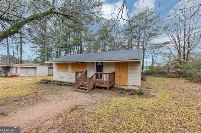 view of front of house featuring a wooden deck and a front yard