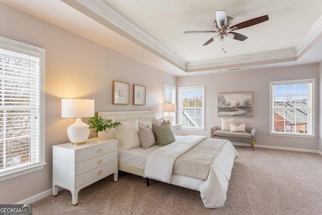 bedroom featuring multiple windows, ornamental molding, a raised ceiling, and carpet flooring