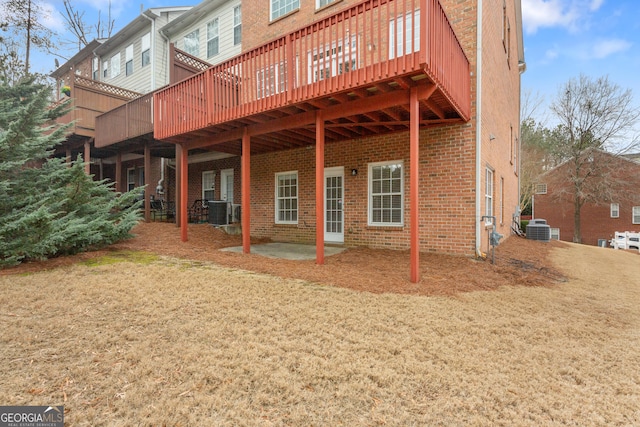 rear view of property featuring a yard, a patio, central air condition unit, and a deck